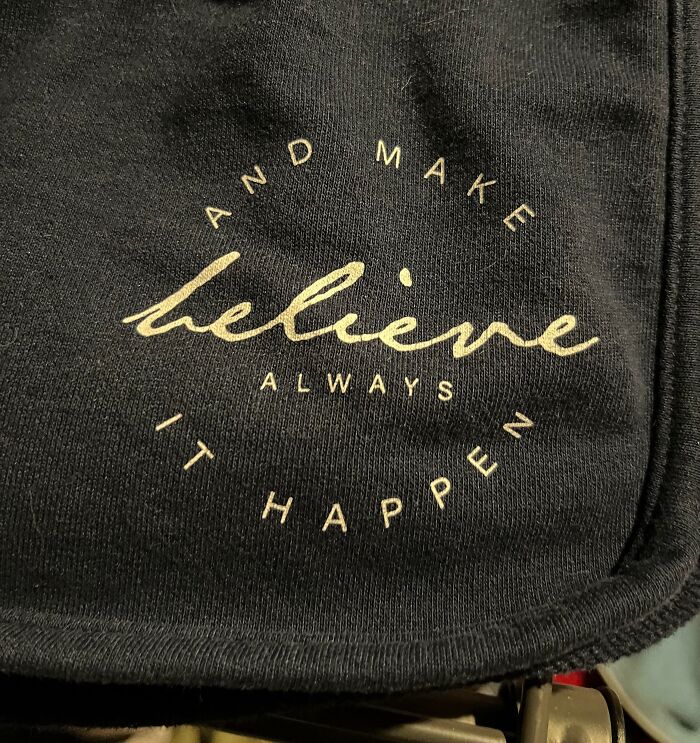 Black fabric with a faded motivational phrase containing a spelling error, illustrating designers failed attempts at writing.