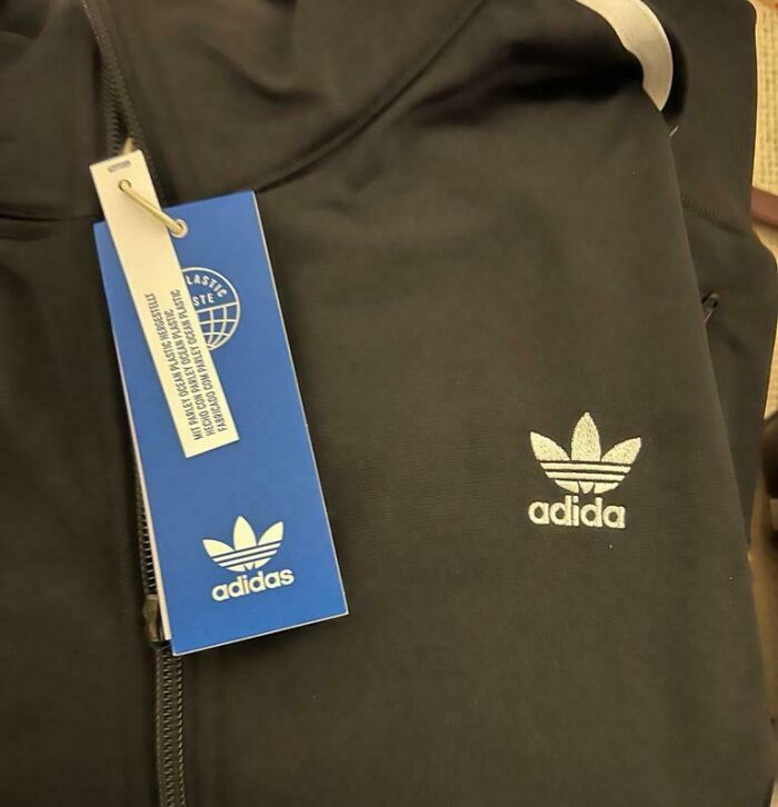Black jacket with a misspelled Adidas logo embroidered, highlighting design fails and branding mistakes by designers.