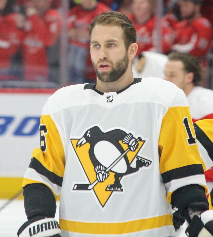 Jason Zucker in Pittsburgh Penguins jersey on ice during a hockey game in an arena with fans in the background