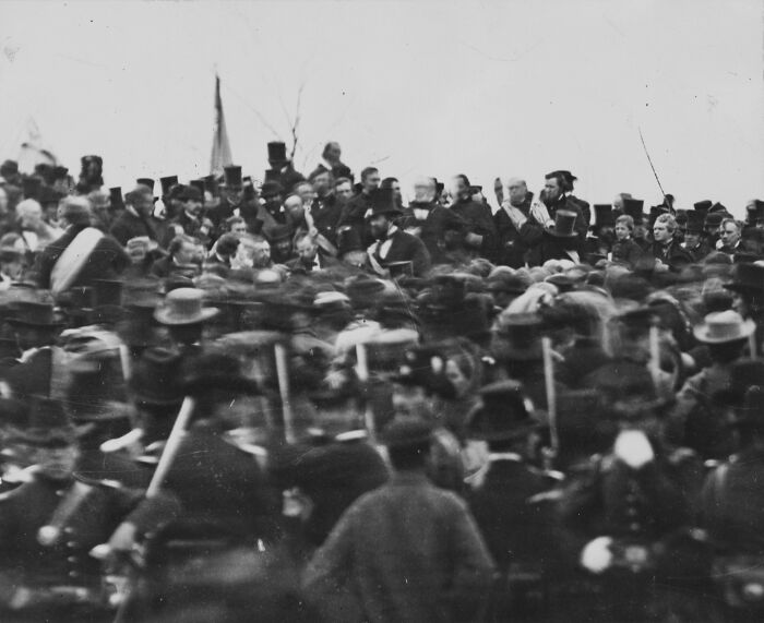Black and white US history photo showing a large crowd of soldiers and civilians at a 19th-century event.