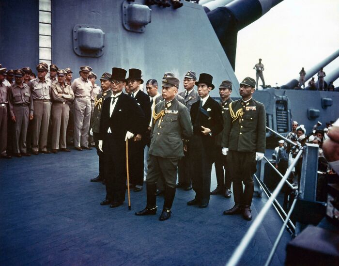 Japanese officials and military officers aboard a US battleship during a historic moment in US history photos.