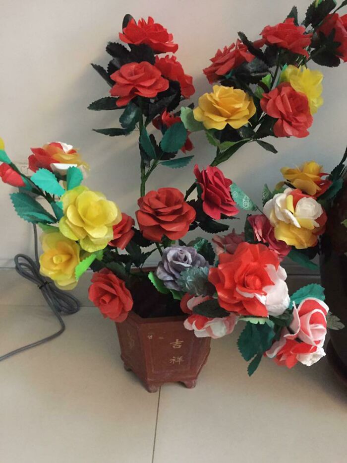 Artificial colorful flowers arranged in a pot, with vivid red, yellow, and orange blooms, illustrating weird teacher behavior concept.