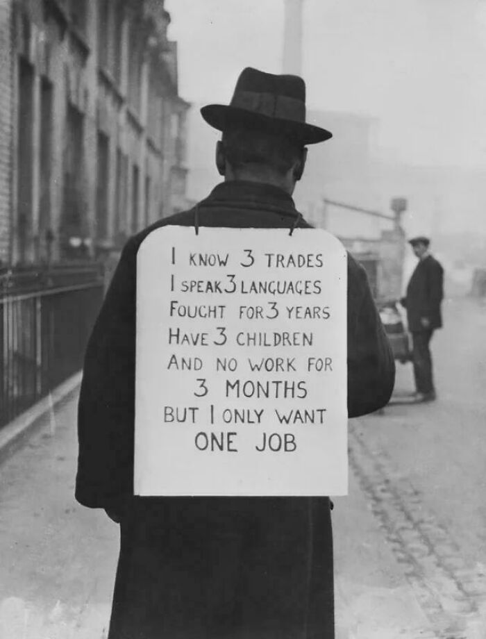 Man wearing a sign about job skills and unemployment during US history, highlighting hardship beyond textbooks.