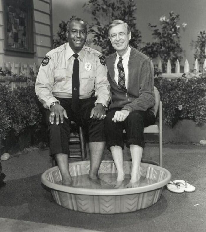 Black and white US history photo of two men sitting with feet in a small pool, showing a rare candid moment.