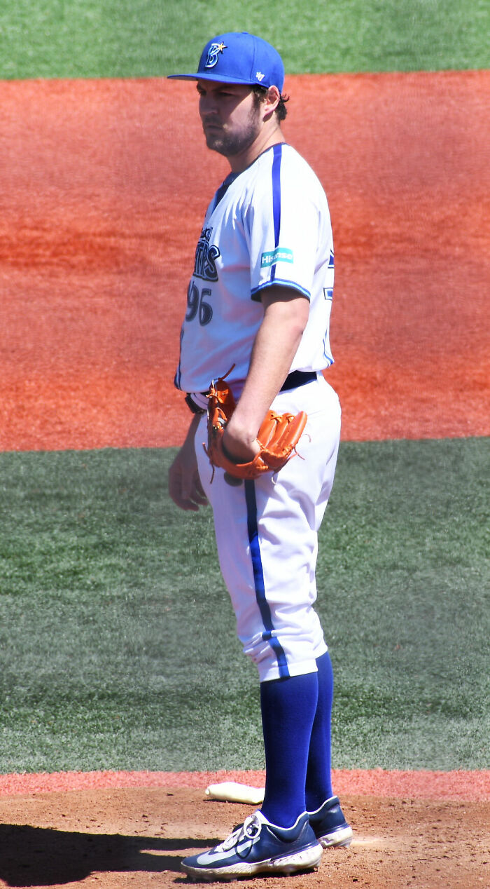 Trevor Bauer standing on the pitcher's mound wearing a baseball uniform and holding a glove during a game.