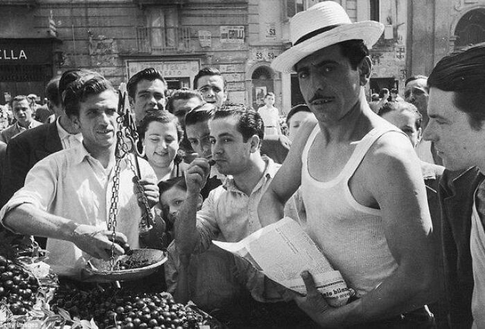 Group of men at a fruit market in a vintage historical photograph depicting a world you'd hardly recognize today.