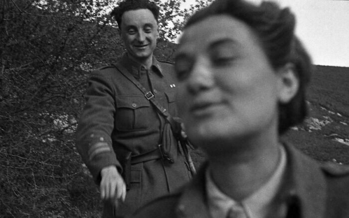 Black and white historical photograph of a soldier smiling behind a woman, depicting a world you'd hardly recognize today.