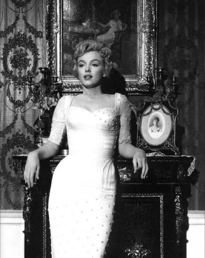 Marilyn Monroe posing in a vintage setting, showcasing a classic dress in an interesting historical photograph.