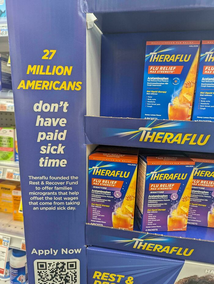 Display of Theraflu flu relief products next to a sign about 27 million Americans lacking paid sick time.