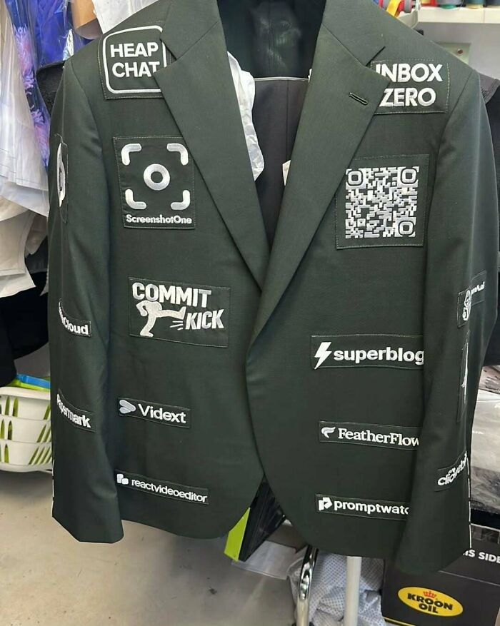 Black blazer with various tech and software patches displayed, reflecting images that make the U.S. look less like a country.