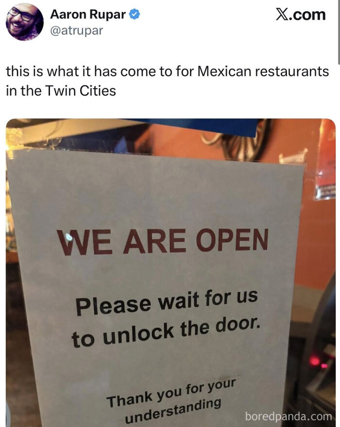 Sign at a Mexican restaurant in the Twin Cities stating they are open but require waiting for door unlocking, reflecting U.S. warnings.