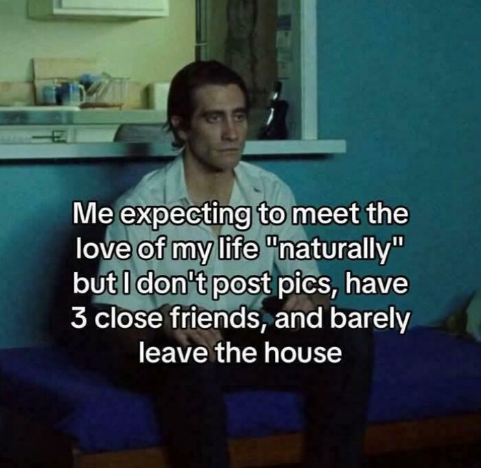 Man sitting alone on couch with relatable meme text about expecting love without social media or many friends.