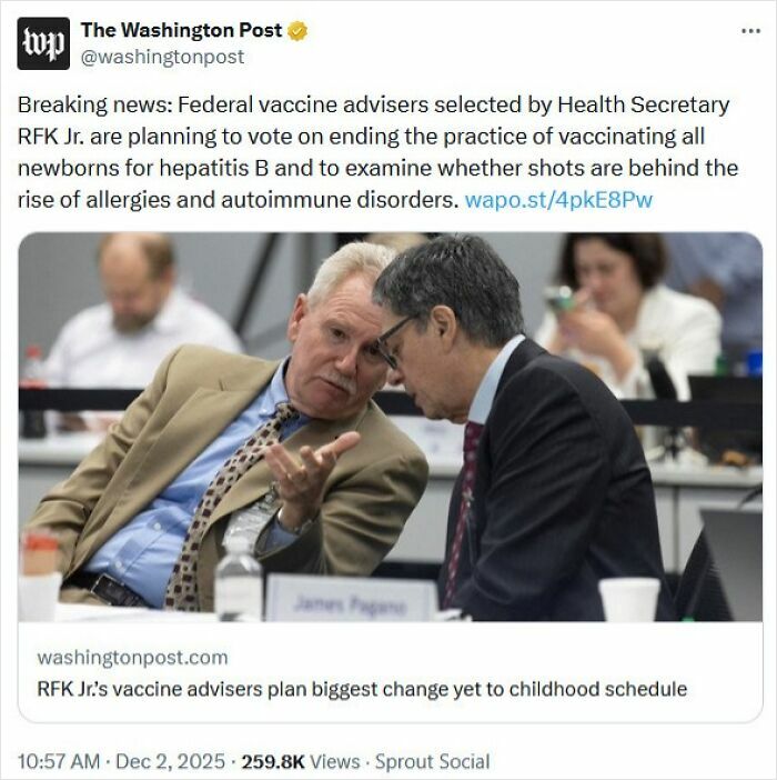 Two men in a formal setting discussing medical knowledge during a vaccine advisory meeting on childhood vaccination changes.