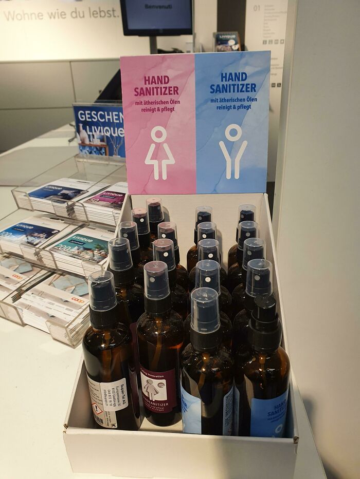 Display of gendered nonsense with pink and blue hand sanitizer bottles labeled for women and men in a retail setting.