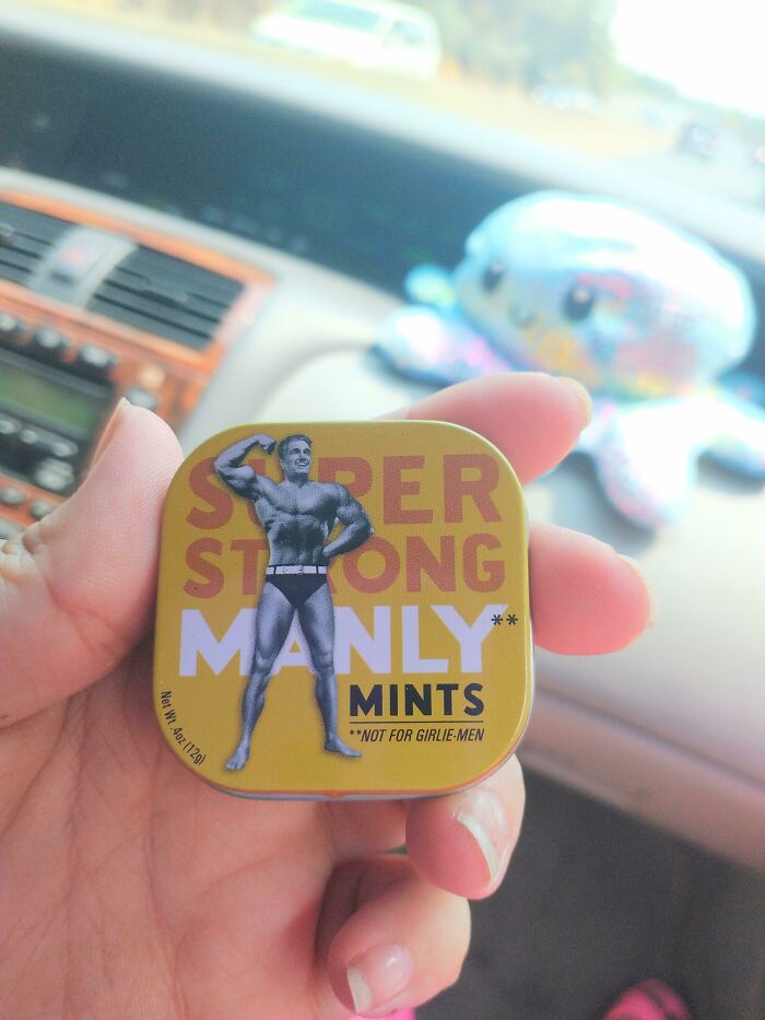Hand holding a tin of mints labeled super strong manly with a muscular figure, highlighting examples of gendered nonsense.