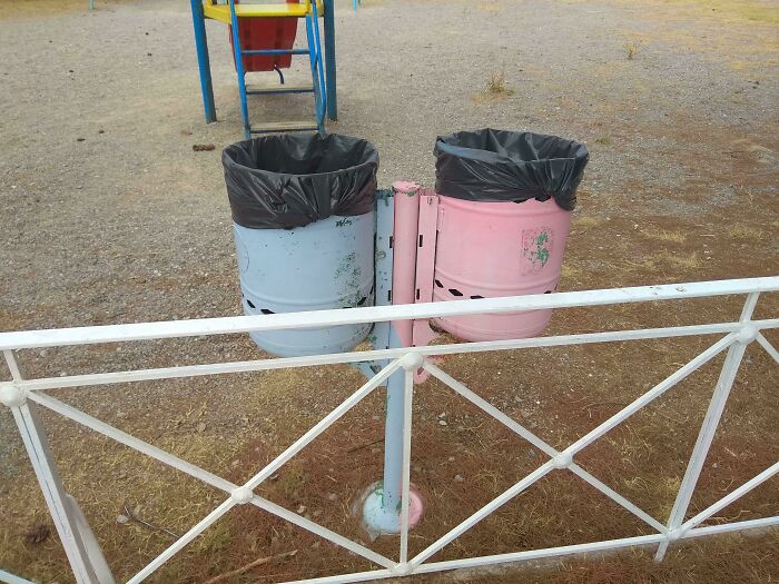 Two outdoor trash bins painted blue and pink, highlighting examples of gendered nonsense in public spaces.