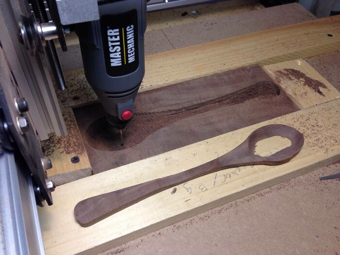 Wooden spoon being carved by a machine showing a failed DIY project with rough and uneven details.