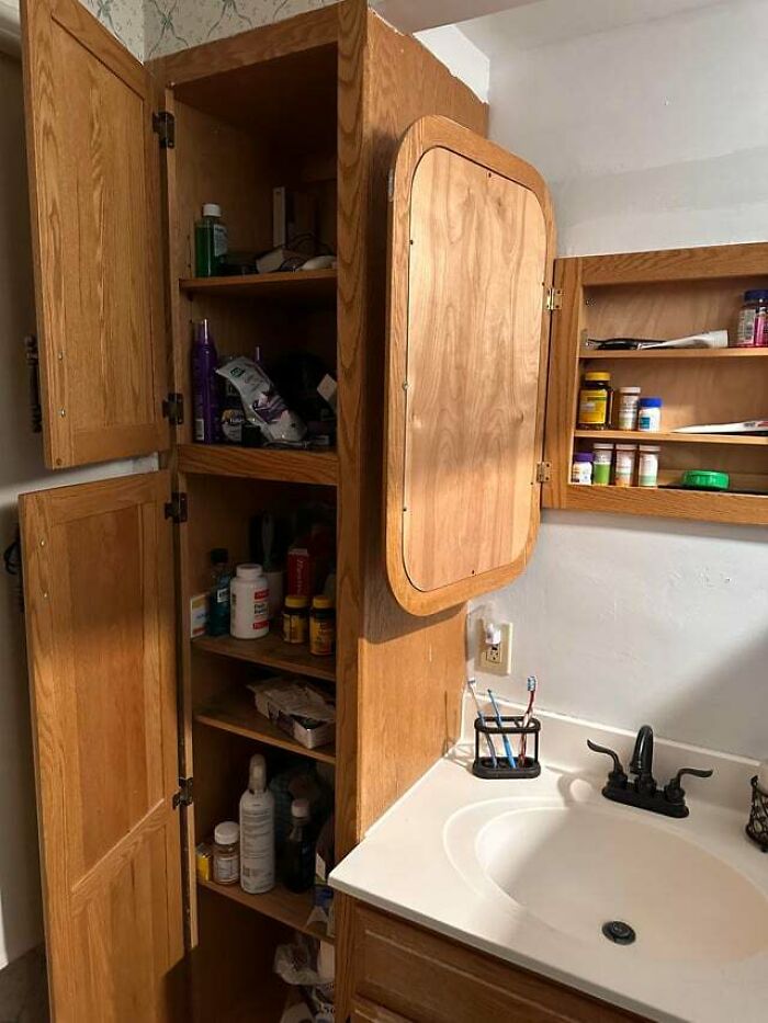 Bathroom cabinets left open with cluttered shelves, a common jerk roommate behavior making others want to live alone.