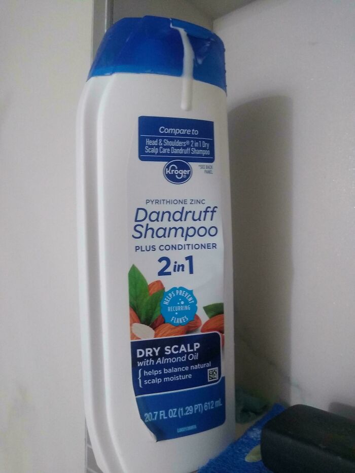 Bottle of dandruff shampoo with conditioner for dry scalp, highlighting roommate frustration and jerk behavior in shared living spaces.