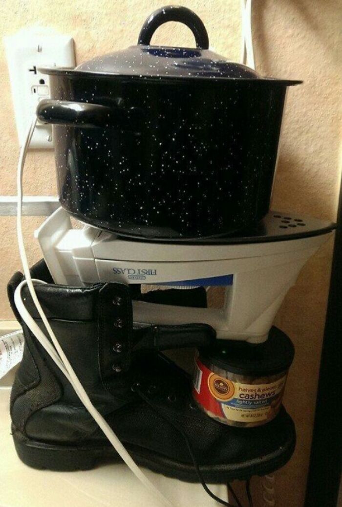 Failed DIY attempt showing a heavy pot balanced on an iron resting on a boot supported by a can of cashews.