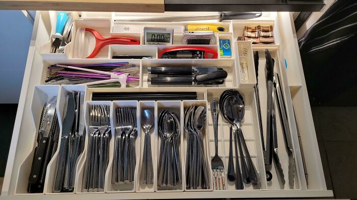 Neatly organized kitchen drawer with cutlery, cooking tools, and utensils arranged for easy access and order.