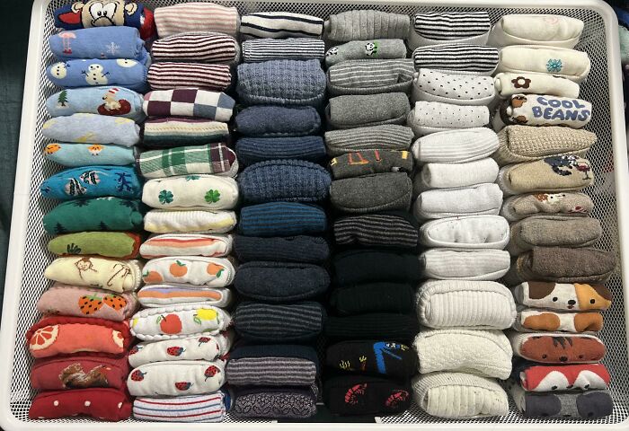 Neatly organized socks arranged by color and pattern in a drawer showcasing satisfying organization.