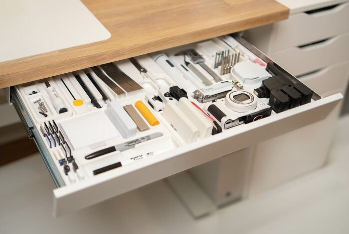Neatly organized drawer with tools, cables, and small devices arranged to bring order into your workspace.