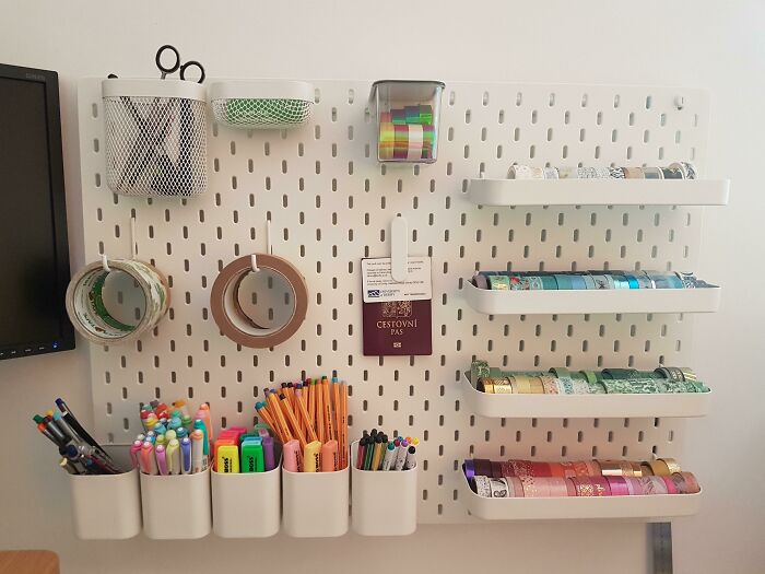 Neatly organized desk supplies and colorful tapes arranged on a white pegboard to bring order into your life.