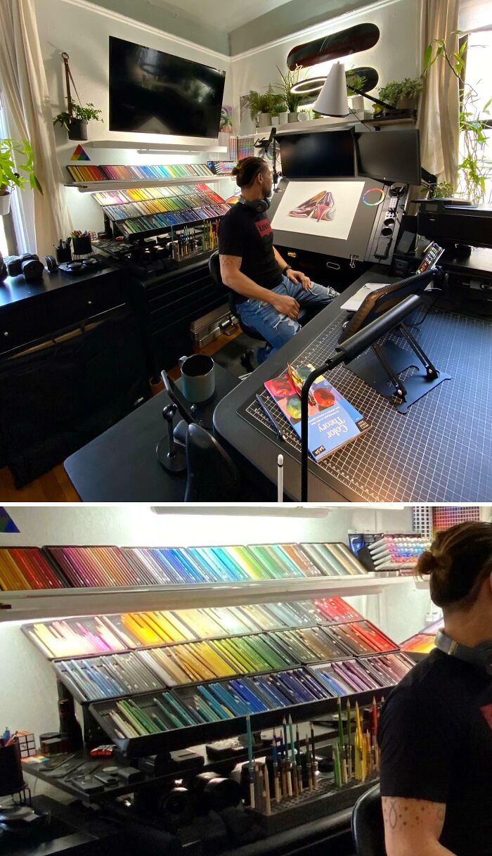 Artist in a neatly organized workspace with color-coded art supplies and multiple monitors for creative work and order.