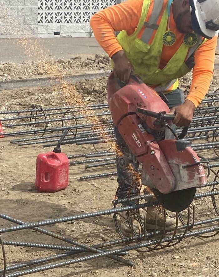 Construction worker using a power saw cutting rebar dangerously close to a gas can, showing reckless work moments needing safety awareness.