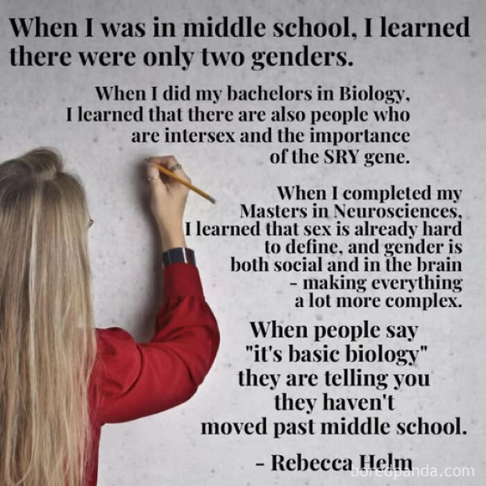 Woman in red writing on wall about gender complexity and biology illustrating straight to the point posts calling out the world.