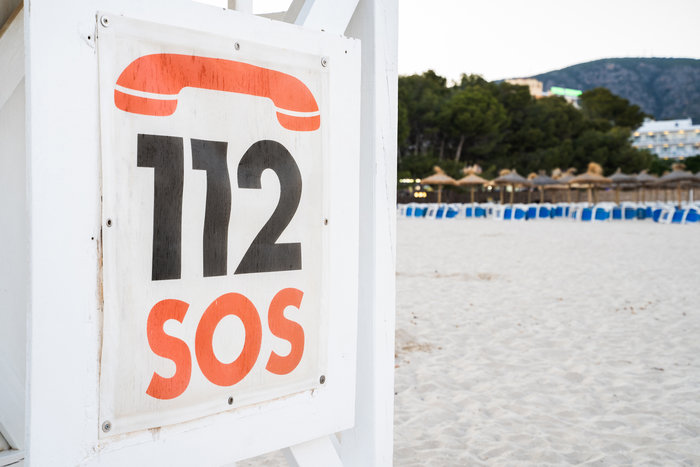 Sinal de emergência SOS com número 112 numa praia, simbolizando missões de resgate e comunicação de ajuda urgente. Sinal de emergência SOS com número 112 numa praia, simbolizando missões de resgate e comunicação de ajuda urgente.