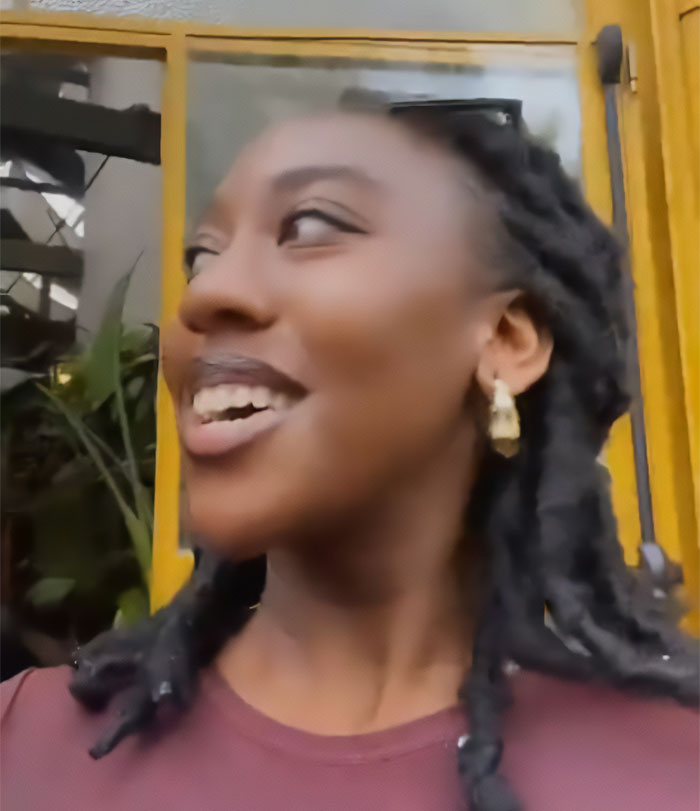South African fan smiling outdoors with braided hair and gold earrings after using filter on selfie with Dua Lipa