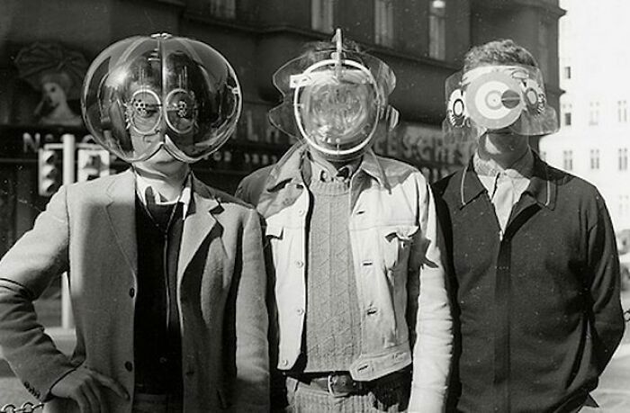 Three men in old black and white pics wearing unusual odd and creepy homemade headgear posing outdoors.