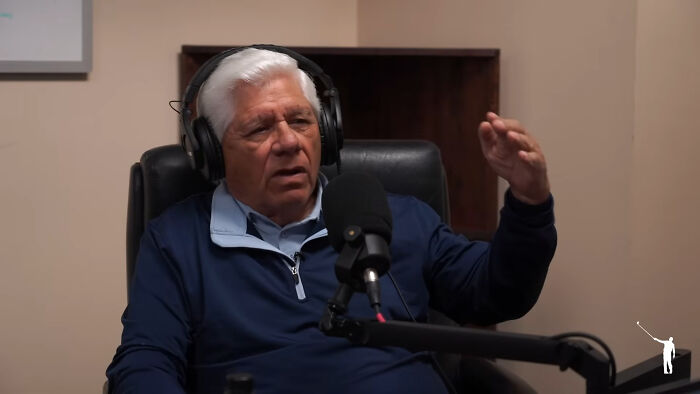 Elderly man with headphones speaking into a microphone during a podcast about meeting idols in real life regrets.