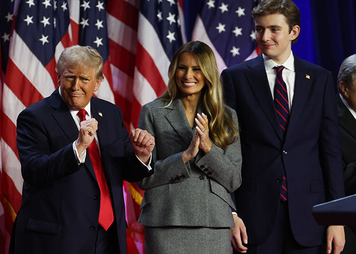 Donald Trump, Melania, and Barron Trump at an event with American flags, linked to Barron Trump marry Princess Isabella viral post. Donald Trump, Melania, and Barron Trump at an event with American flags, linked to Barron Trump marry Princess Isabella viral post.
