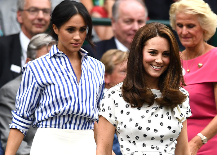 Kate Middleton smiling in a white dress with black polka dots, alongside Meghan Markle in a blue striped shirt. Kate Middleton smiling in a white dress with black polka dots, alongside Meghan Markle in a blue striped shirt.