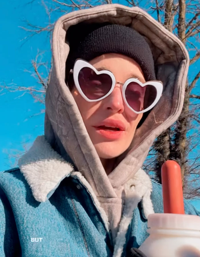 Kelly Osbourne wearing heart-shaped sunglasses and layered winter clothing in an outdoor video clip. Kelly Osbourne wearing heart-shaped sunglasses and layered winter clothing in an outdoor video clip.