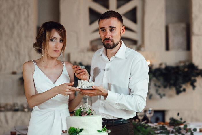 Bride and groom feeding cake to each other during wedding celebration, highlighting fastest times couples said I do and I’m done.