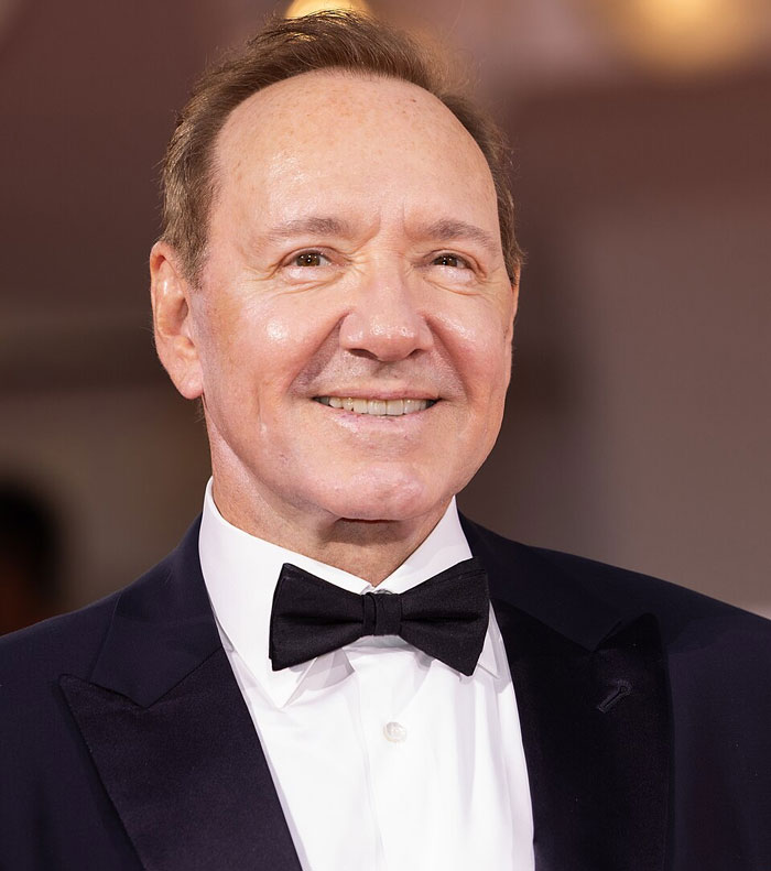 Male celebrity in a tuxedo smiling at an event, representing celebrities whose careers crashed and never recovered.