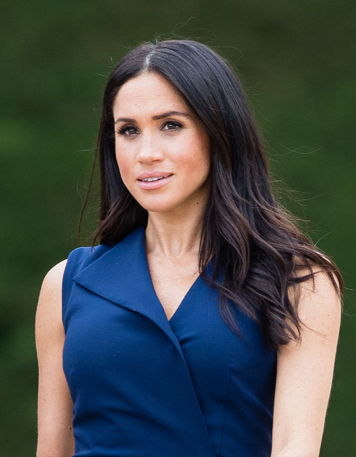 Meghan Markle in a sleeveless blue dress posing outdoors, part of viral Meghan Markle evil stare compilation content. Meghan Markle in a sleeveless blue dress posing outdoors, part of viral Meghan Markle evil stare compilation content.