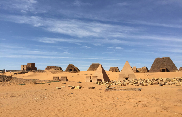 Ancient pyramids and ruins in a desert under a blue sky, representing one of the oldest countries in the world.
