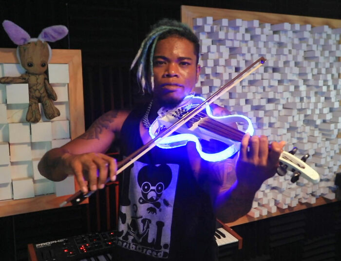Musician playing a glowing electric violin in a studio setting, related to Will Smith accused of harassing and grooming. Musician playing a glowing electric violin in a studio setting, related to Will Smith accused of harassing and grooming.