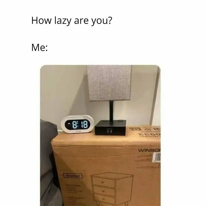 Relatable introvert meme showing a lamp and clock on a cardboard box used as a nightstand for life as an introvert.