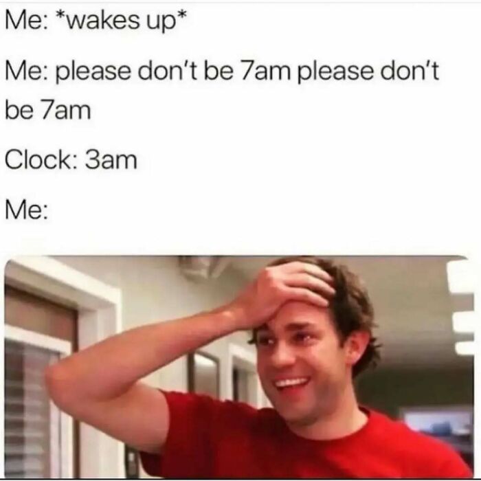 Man in red shirt smiling and holding head, illustrating relatable introvert meme about waking up too early.