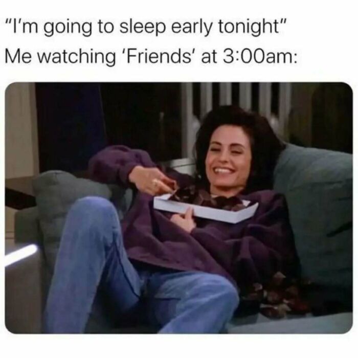 Woman smiling on couch eating chocolates late at night, illustrating timeless Friends memes and posts about binge-watching the show.