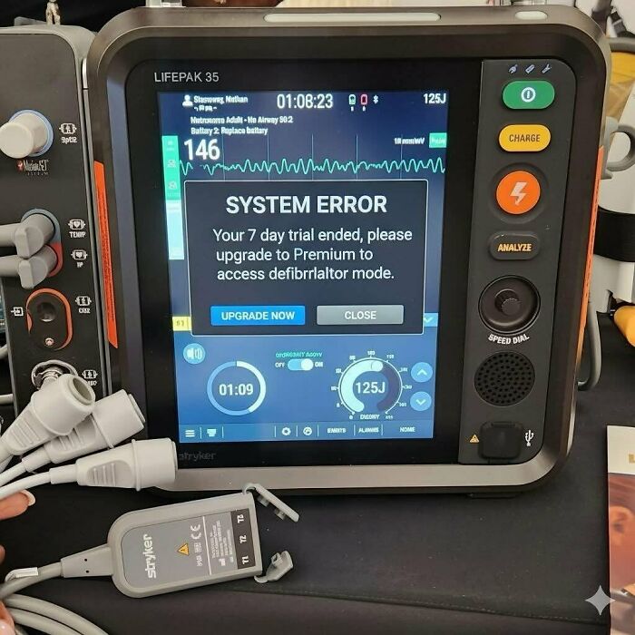Defibrillator screen showing system error message about trial ending, highlighting humor in expensive healthcare memes.