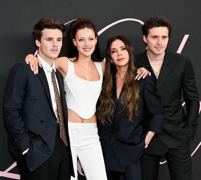 Brooklyn Beckham and Nicola Peltz with parents posing at a formal event, sparking theories about Nicola&rsquo;s background.