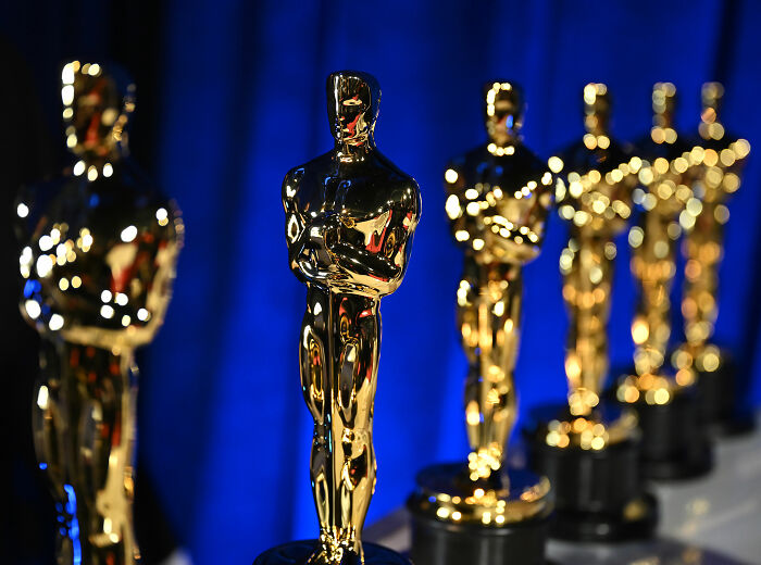 Shiny golden Oscar statuettes lined up against a blue background for Academy 2026 Oscar nominations event. Shiny golden Oscar statuettes lined up against a blue background for Academy 2026 Oscar nominations event.