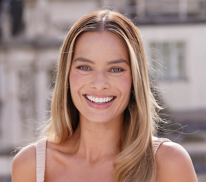 Margot Robbie smiling outdoors, highlighting her on-set relationship with Wuthering Heights co-star Jacob Elordi rumors.